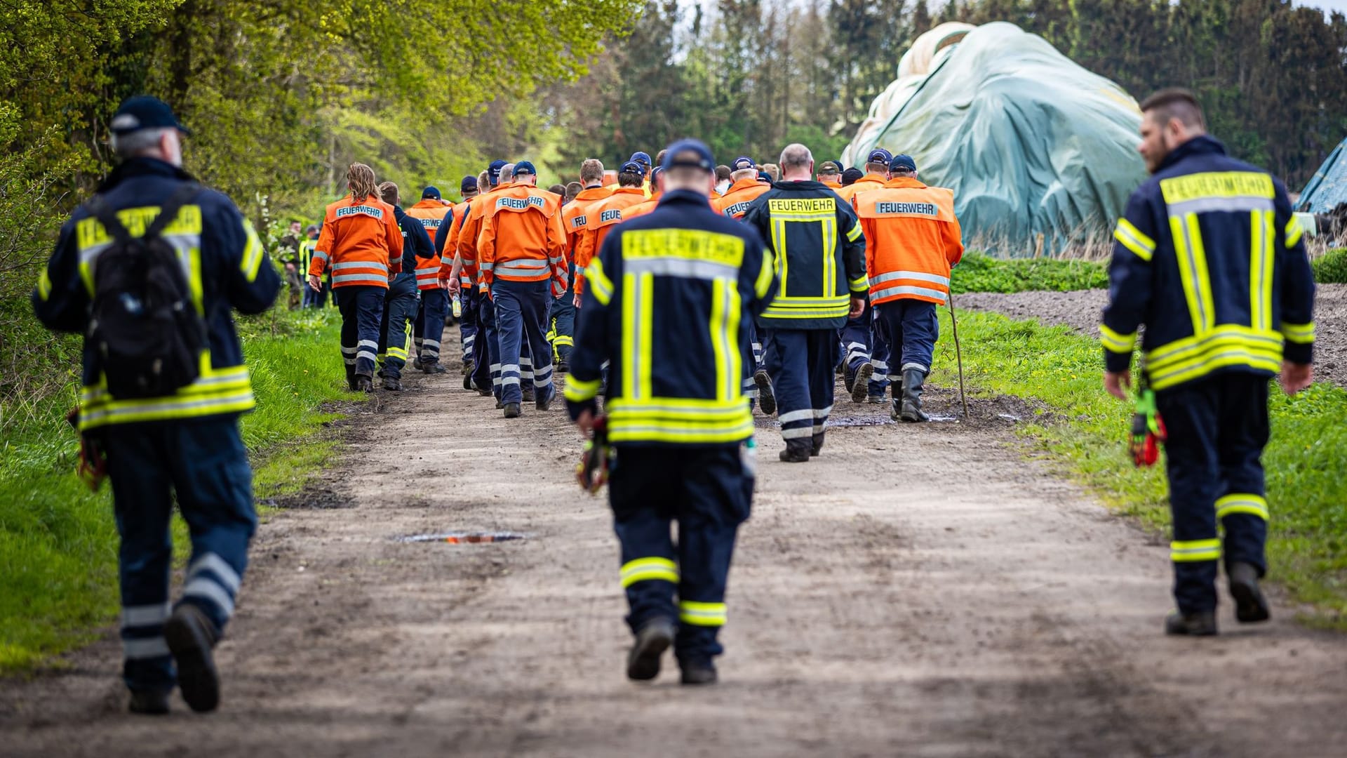 Einsatzkräfte der Feuerwehr gehen am Wochenende eine Straße im Landkreis Stade entlang. Mittlerweile ist der großflächige Einsatz beendet – die Suche nach Arian wurde eingestellt.