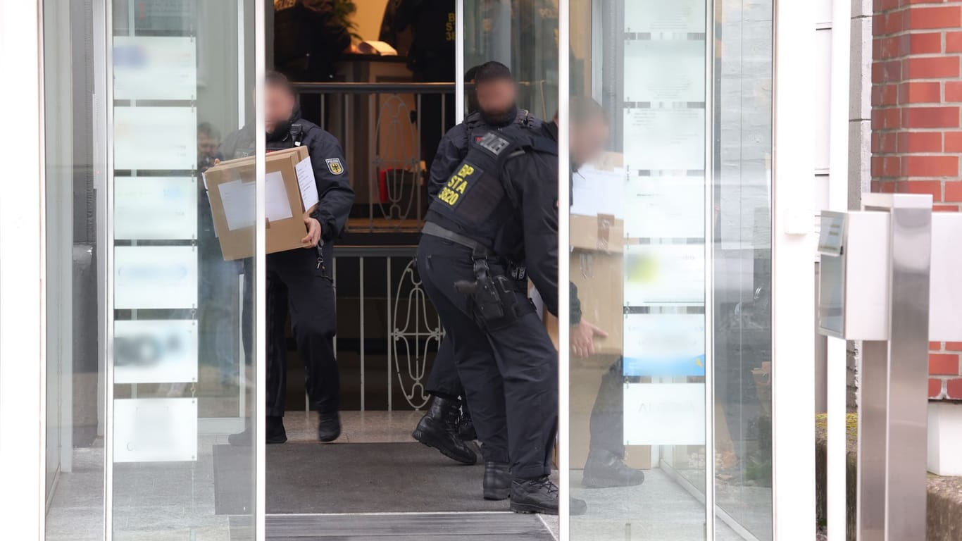 Solingen am 17. April: Polizeibeamte tragen in Kartons sichergestelltes Material aus einem Gebäude.