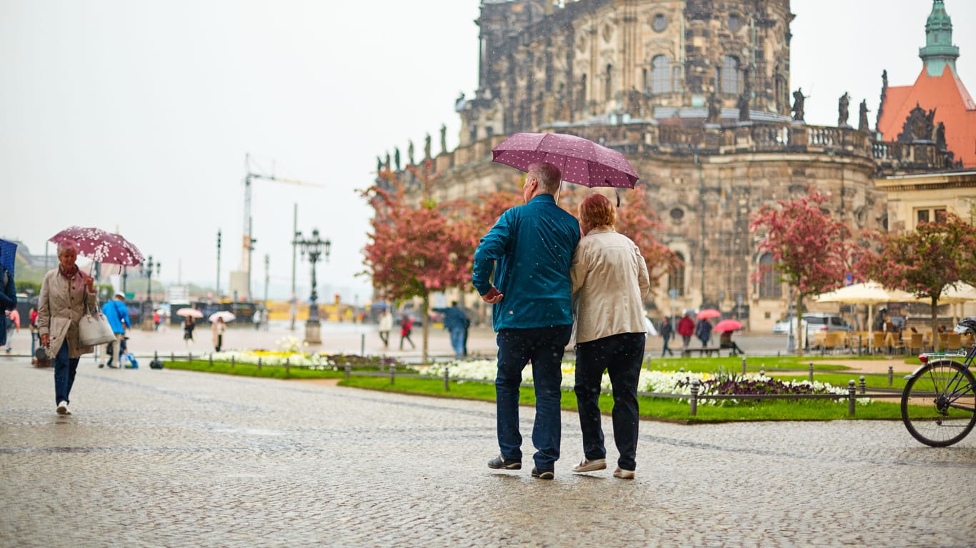 Fußgänger gehen im Regen durch Dresden (Symbolbild): Ab Montag zieht das Wetter seine ungemütliche Seite auf.