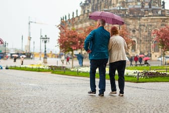 Fußgänger gehen im Regen durch Dresden (Symbolbild): Ab Montag zieht das Wetter seine ungemütliche Seite auf.