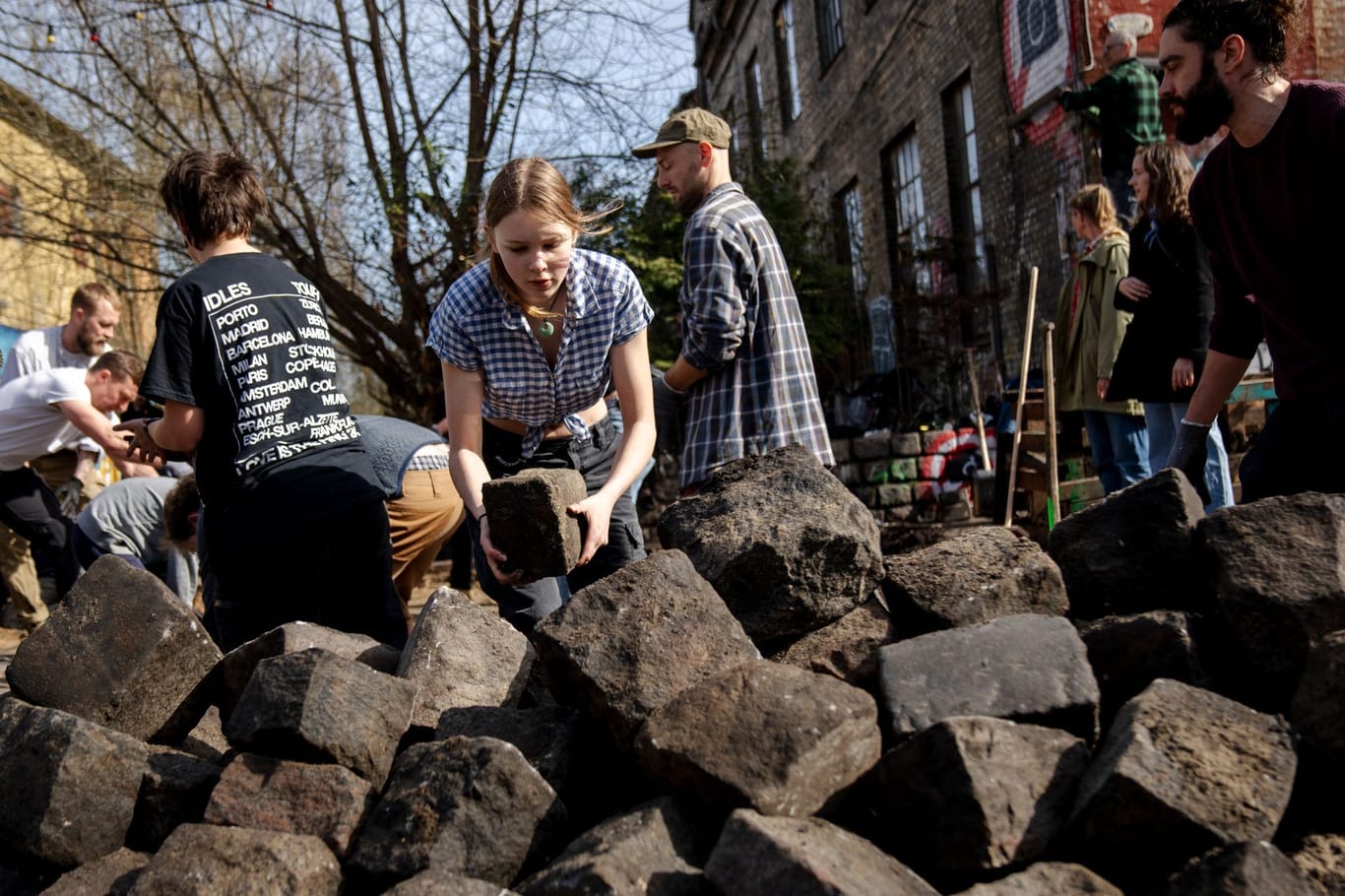 Lieber keine Straße als eine für Dealer: Bürger und Bürgerinnen der Freistadt Christiania graben gemeinsam das Kopfsteinpflaster in der Pusher Street aus. Sie soll anschließend renoviert werden.