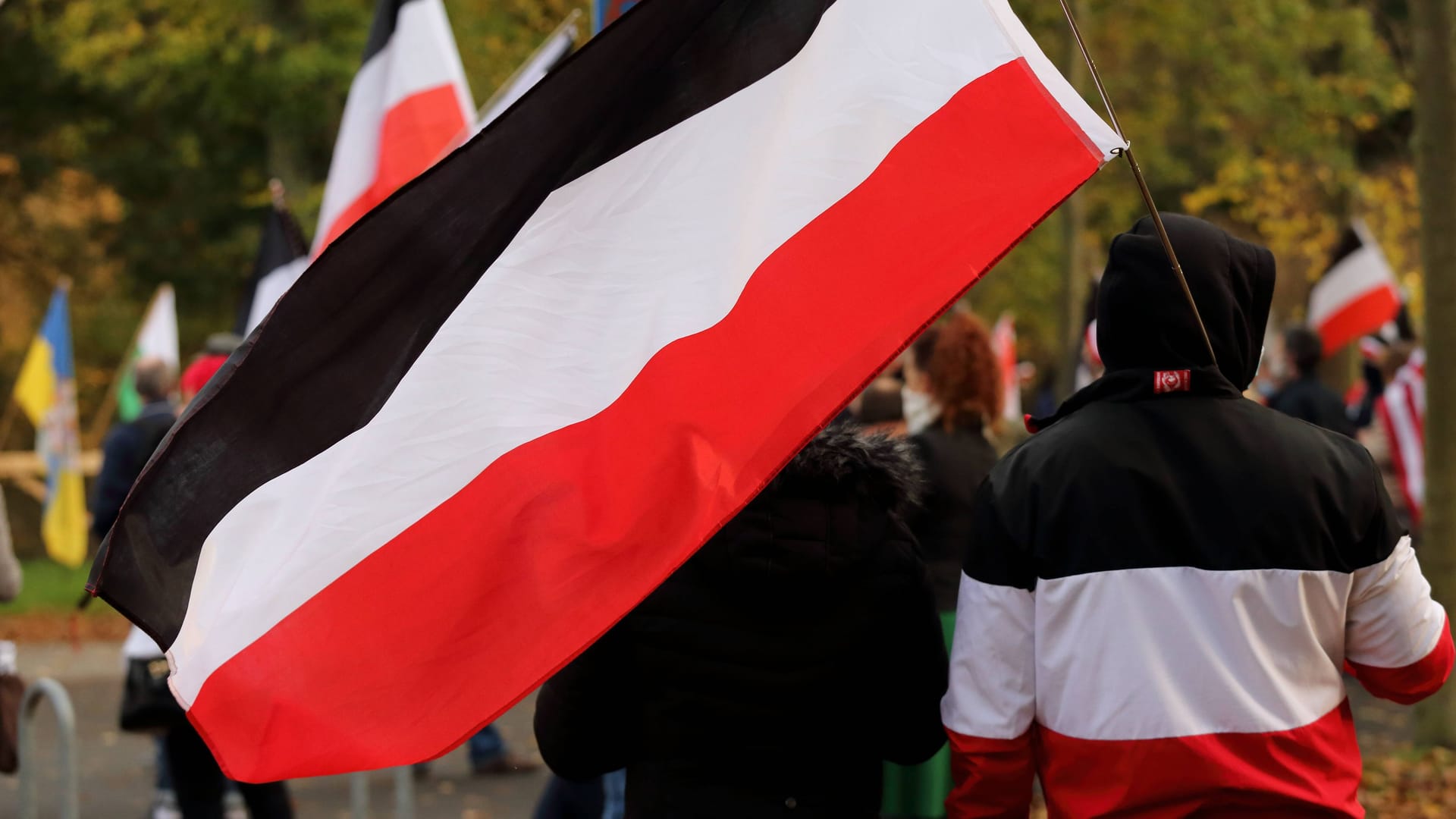 Ein Teilnehmer einer Reichsbürger-Demonstration hält eine schwarz-weiß-rote Reichsflagge in der Hand. (Symbolbild)