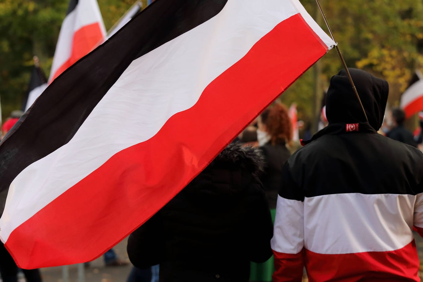 Ein Teilnehmer einer Reichsbürger-Demonstration hält eine schwarz-weiß-rote Reichsflagge in der Hand. (Symbolbild)