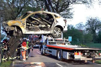 Das abgebrannte Auto wird geborgen: Zwei Tote bei einem Autounfall in Bissendorf.