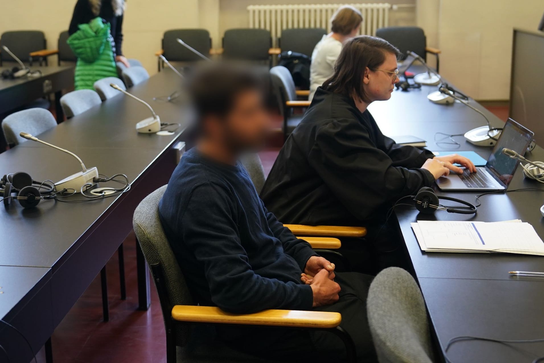 Der Angeklagte (vorne) zu Beginn des Prozesses im Sitzungssaal: Ihm werden Geiselnahme, Entziehung Minderjähriger, vorsätzlicher Körperverletzung und Waffendelikten vorgeworfen.