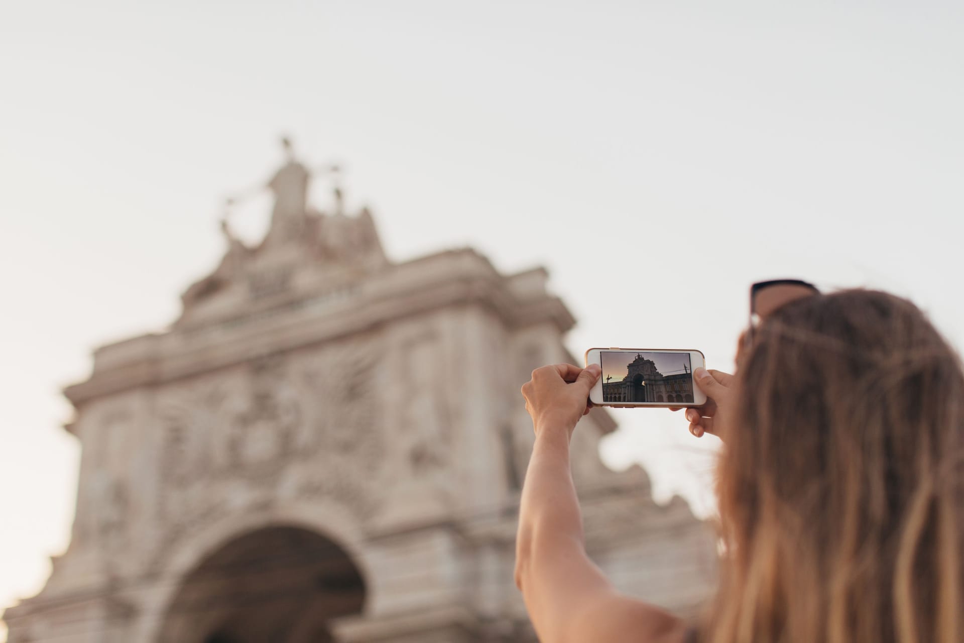 Den Moment für immer festhalten: Eine Frau fotografiert mit ihrem Smartphone ein Motiv in Lissabon.