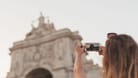 Den Moment für immer festhalten: Eine Frau fotografiert mit ihrem Smartphone ein Motiv in Lissabon.