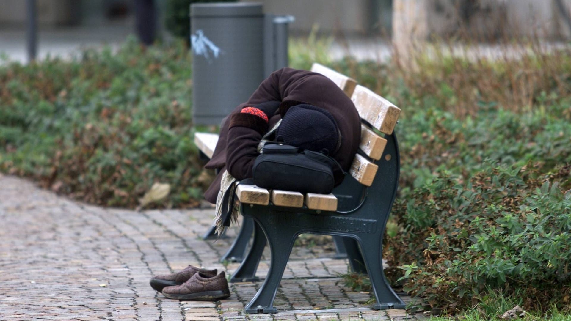 Ein Mann schläft in Frankfurt auf einer Bank (Symbolbild).