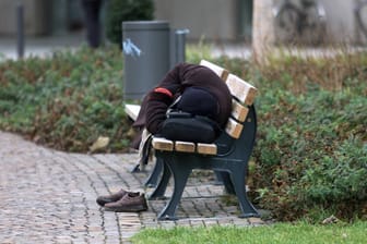 Ein Mann schläft in Frankfurt auf einer Bank (Symbolbild).