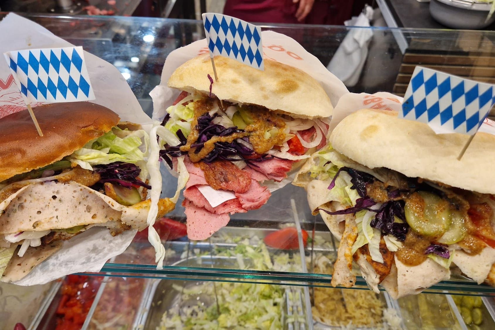 Die drei "Bayern-Döner": "Klassisch" mit Leberkäse (m.) oder seit neustem auch mit Weißwurst (l.) oder Bratwurst (r.).