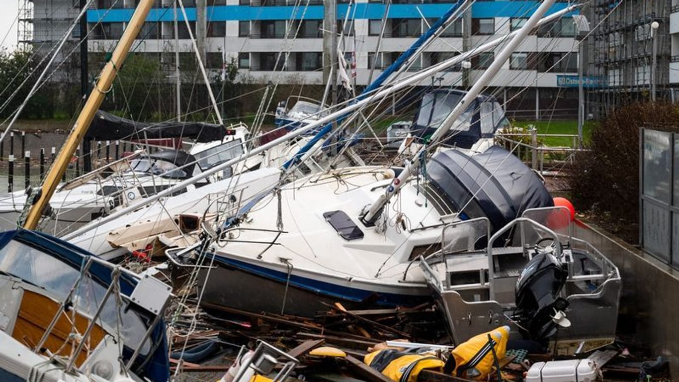 Beschädigte Schiffe liegen im Hafen nach einer Sturmflut auf einem Anleger (Archivbild): Der Sturm im vergangenen Oktober verursachte viele Millionen Euro an Schäden.