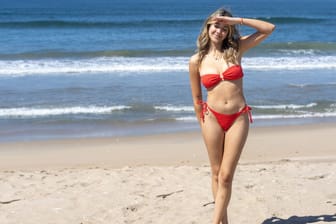 Smiling woman in red bikini posing on a sunny beach. Huntington Beach, California, United States R_RILV240423-1409633-01 ,model released, Symbolfoto