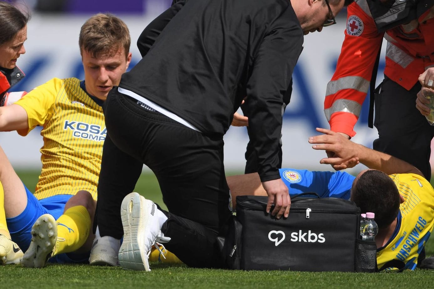 Braunschweigs Robert Ivanov (l) und Hasan Kurucay werden auf dem Spielfeld nach einem Zusammenprall behandelt: Die Verteidiger wirkten beide benommen.