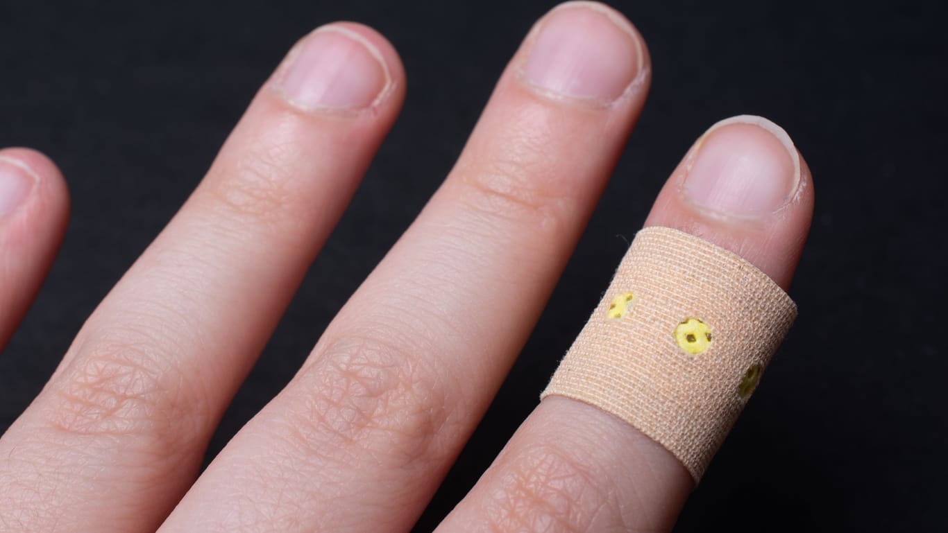 Bandage patch on a person's finger on a black background