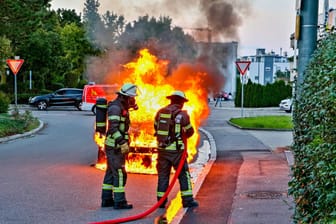 Einsatzkräfte der Feuerwehr löschen ein brennendes Auto (Symbolbild): Der entstandene Schaden durch die Anschlagsserie geht in die Millionen.