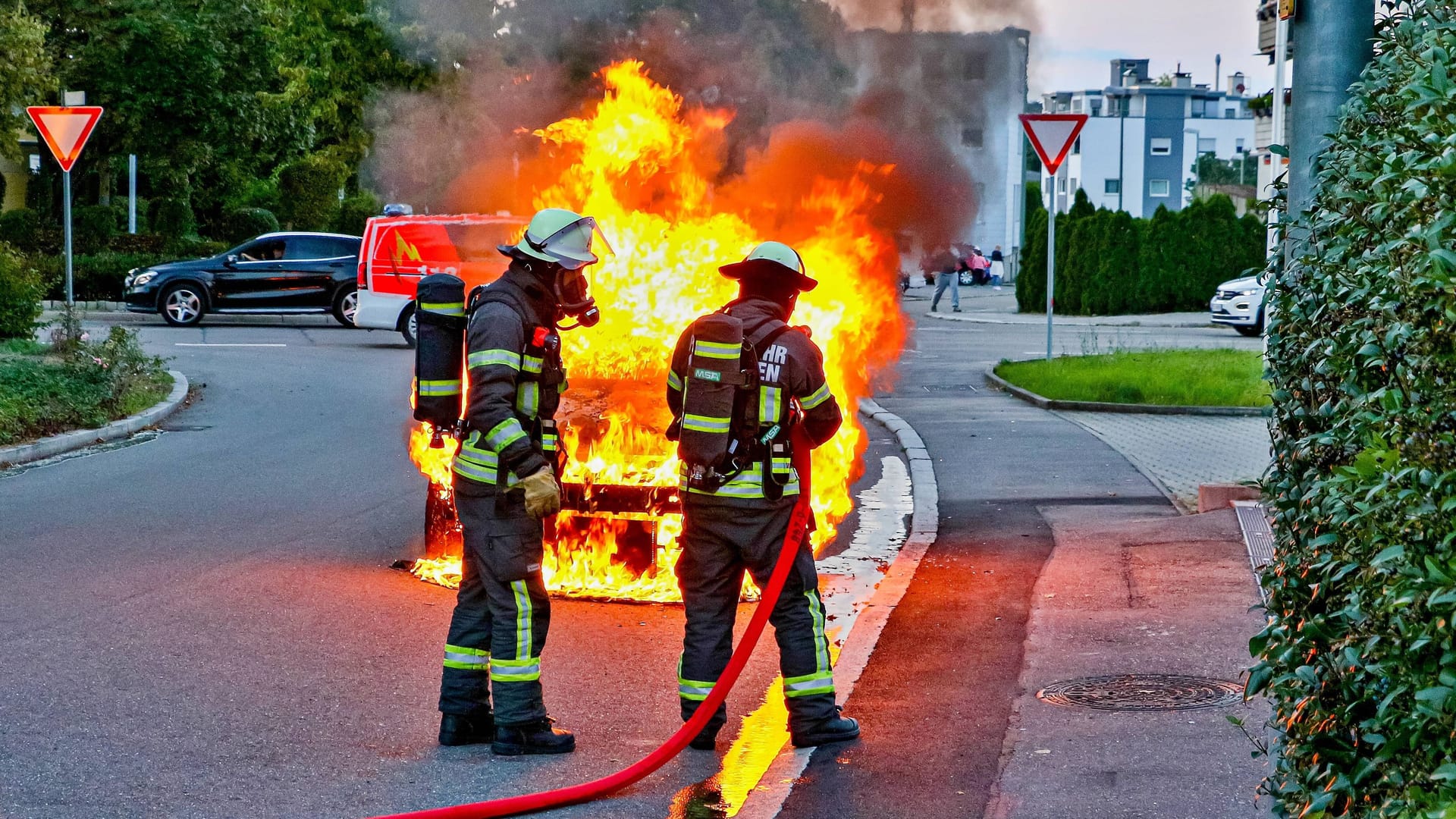 Einsatzkräfte der Feuerwehr löschen ein brennendes Auto (Symbolbild): Der entstandene Schaden durch die Anschlagsserie geht in die Millionen.