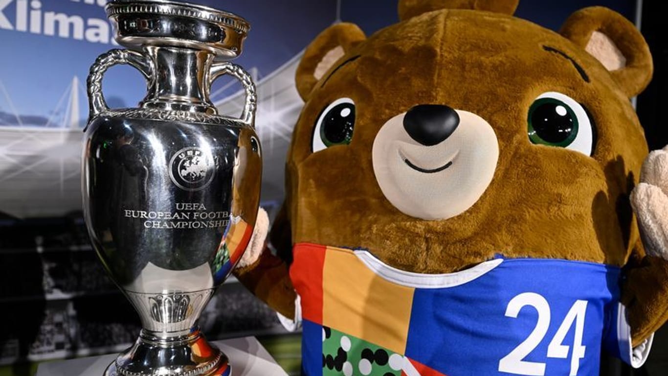 Albert, Maskottchen der Fußball-Europameisterschaft (EM) in Deutschland, steht neben dem EM-Pokal: Die Trophäe ist am Samstag in Köln.