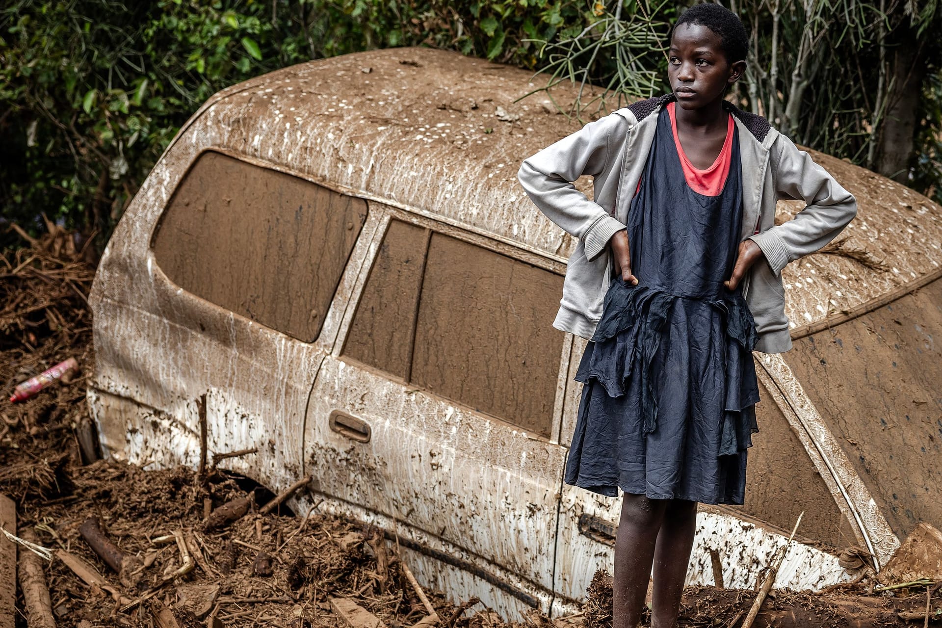 Ein kenianisches Mädchen steht neben einem im Schlamm versunkenen Auto. Aufgrund der starken Regenfälle sind schon über 140 Menschen in Kenia verstorben.