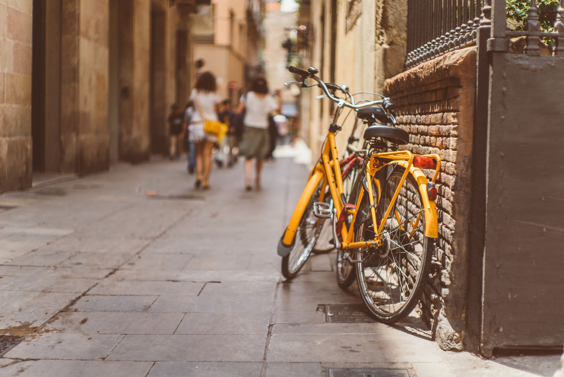 Hübscher Schnappschuss in den Gassen von Barcelona: Ein sonnengelbes Fahrrad lehnt an einer Hauswand.
