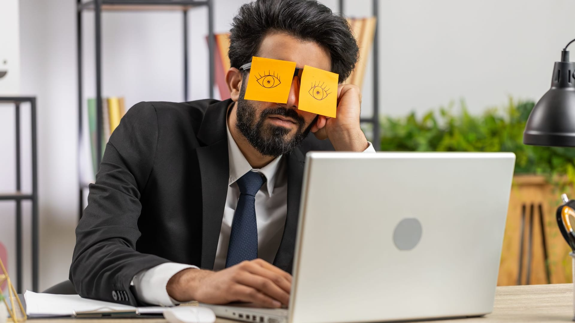 Geschäftsmann schläft hinter aufgemalten Augen auf Post-its