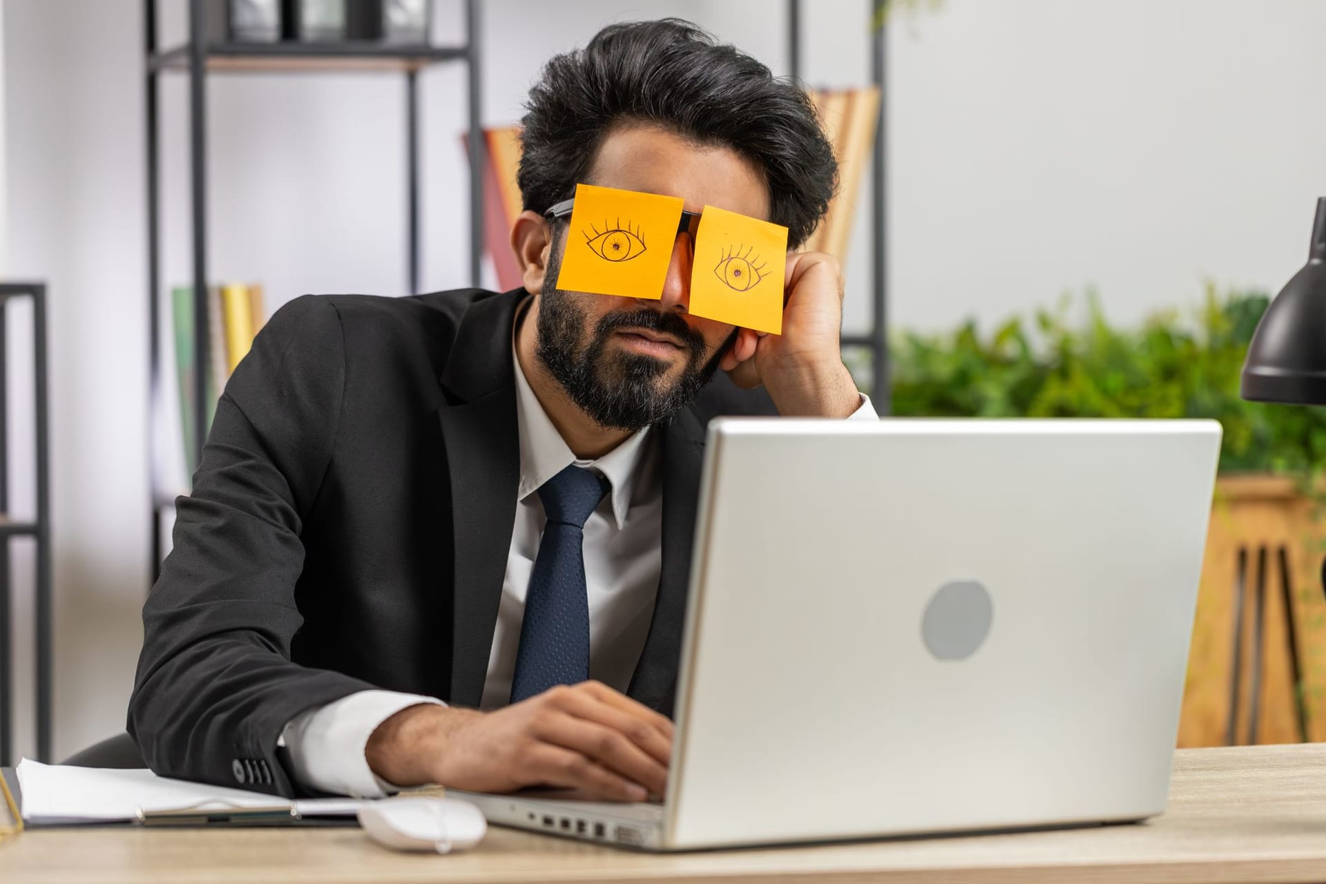 Geschäftsmann schläft hinter aufgemalten Augen auf Post-its