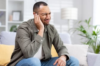 Mann mit Ohrenschmerzen: Eine bösartige Gehörgangsentzündung kann aus einer gewöhnlichen Gehörgangsentzündung hervorgehen, wenn das Immunsystem geschwächt ist.