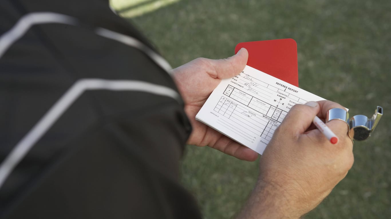 Ein Schiedsrichter hält eine Rote Karte in der Hand (Symbolfoto): Der Bremer Fußball-Verband hat einen Spieler mit der Höchststrafe belegt.