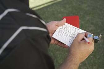 Ein Schiedsrichter hält eine Rote Karte in der Hand (Symbolfoto): Der Bremer Fußball-Verband hat einen Spieler mit der Höchststrafe belegt.