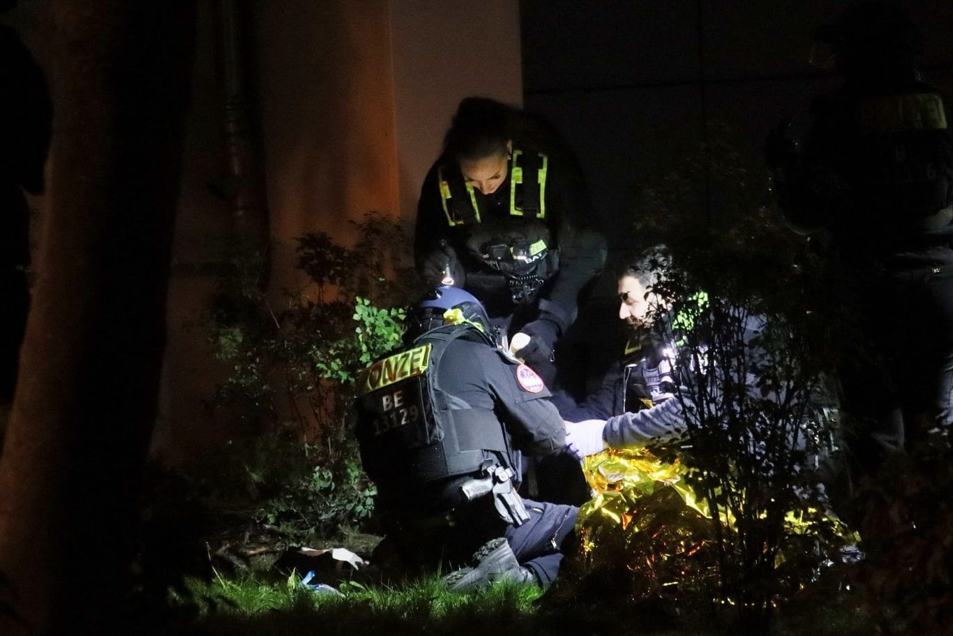 Berliner Polizisten kümmern sich um einen Verletzten in Lichtenberg.