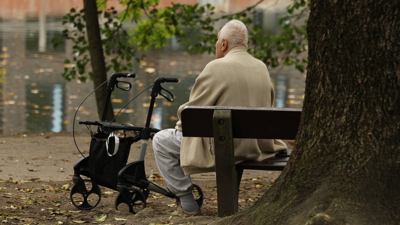 Mann sitzt auf einer Parkbank (Symbolbild): Der Senior erlitt durch den Angriff Kopfverletzungen.