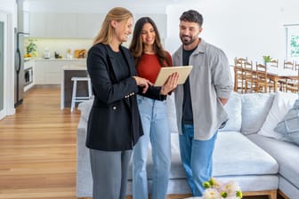 Immobilienmaklerin zeigt Paar eine Mietwohnung
