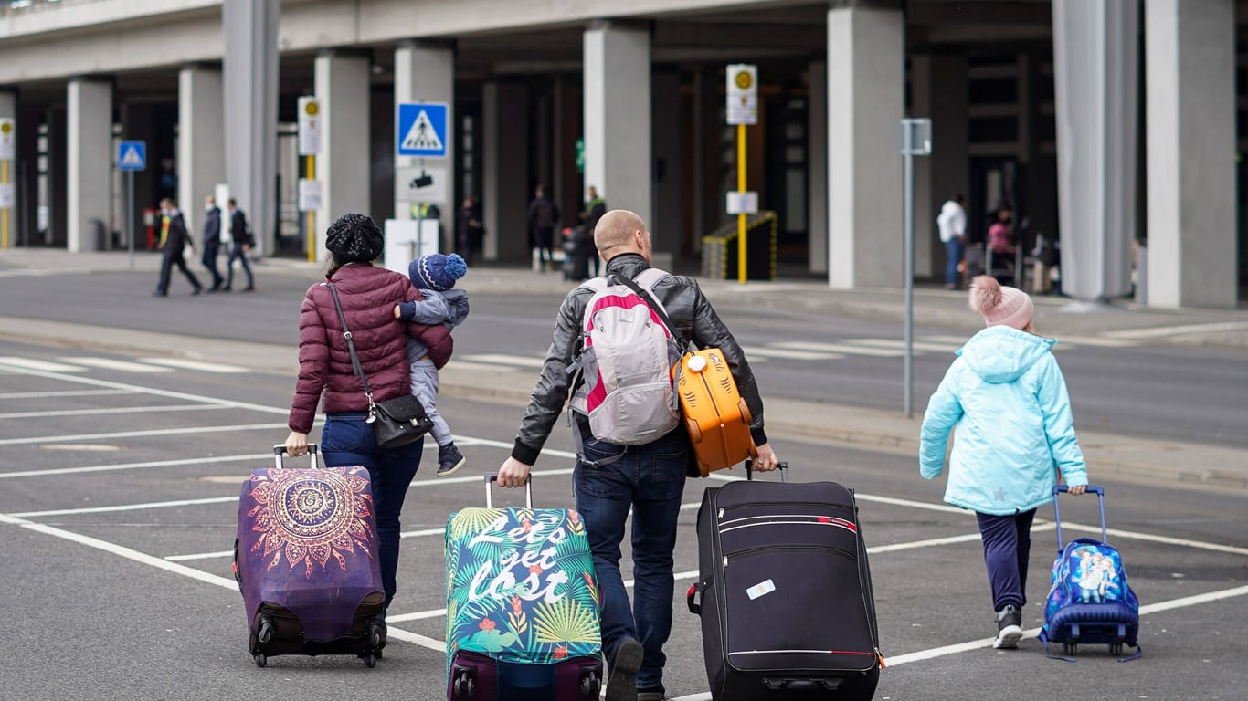 Eine Familie auf dem Weg zum Flughafen (Archivbild): Eine Absenkung der Emissionen scheint im Flugverkehr bisher schwierig.