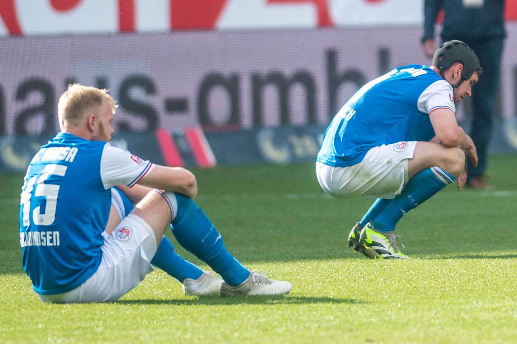 Rostocker Spieler enttäuscht am Boden: Der Abstieg in die 3. Liga ist perfekt.