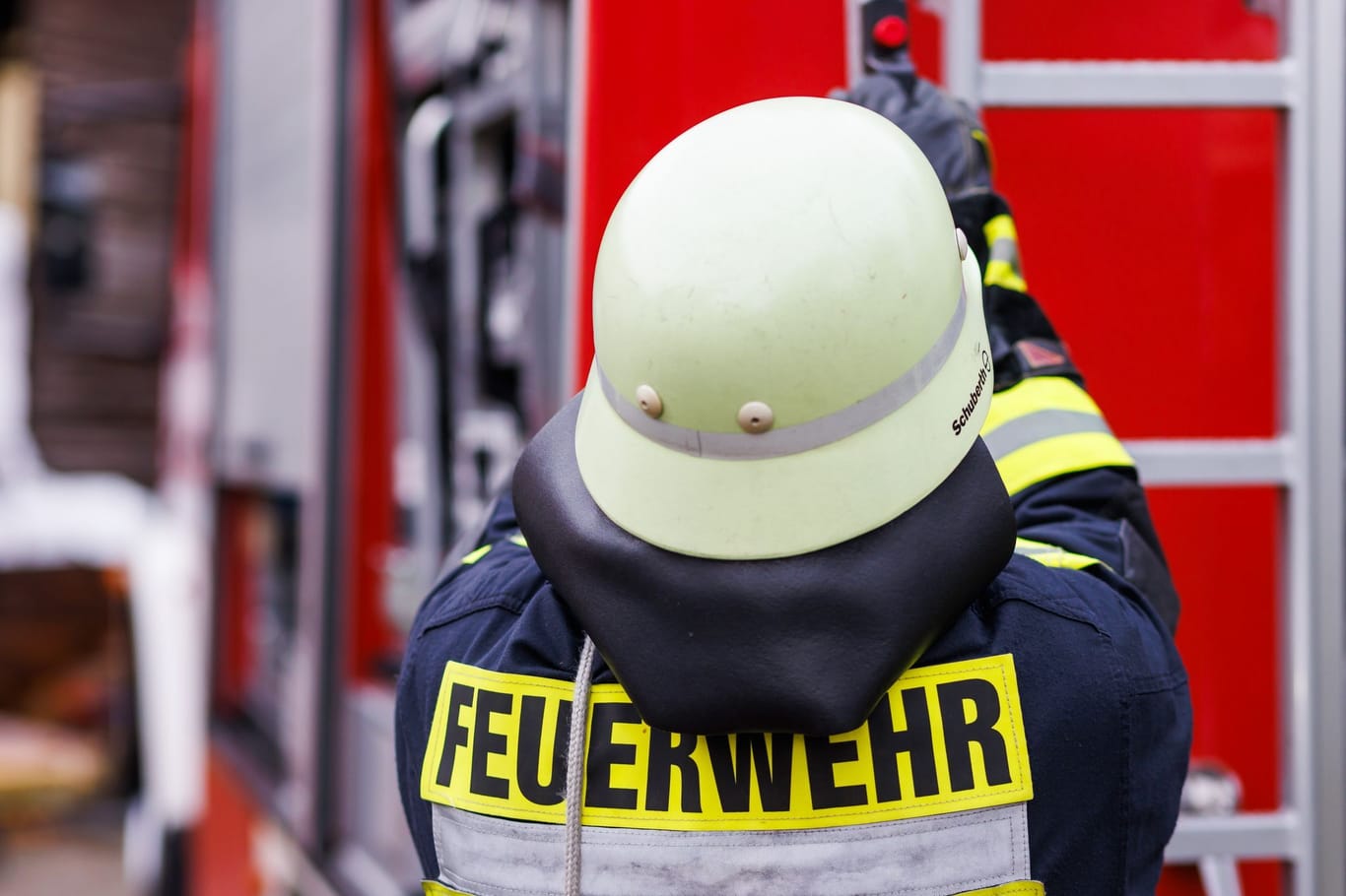 Ein Feuerwehrmann an einem Einsatzfahrzeug (Symbolbild): Nach heftigen Regenfällen liegen in Mannheim Keller voll.