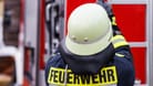 Ein Feuerwehrmann an einem Einsatzfahrzeug (Symbolbild): Nach heftigen Regenfällen liegen in Mannheim Keller voll.