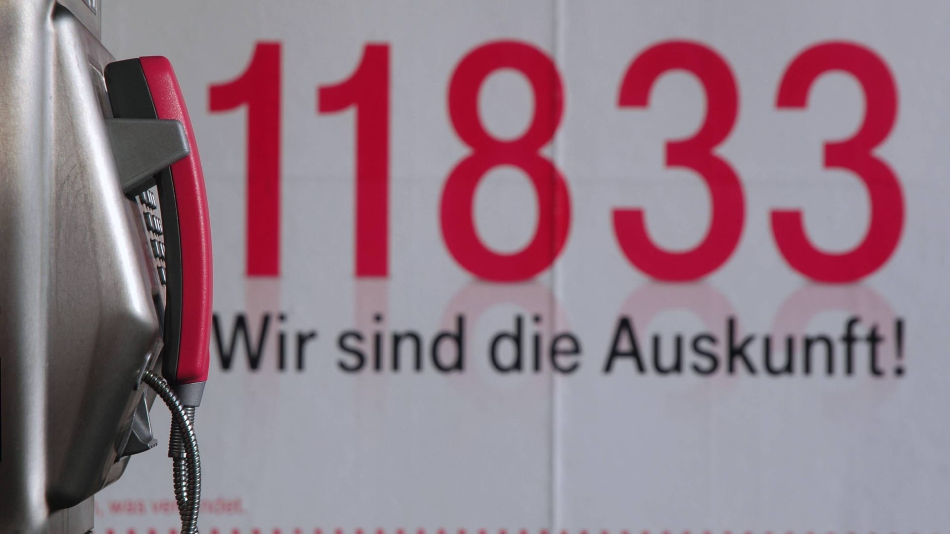 Die Nummer der Auskunft und ein öffentliches Telefon: Zwei Relikte aus einer längst vergangenen Zeit.