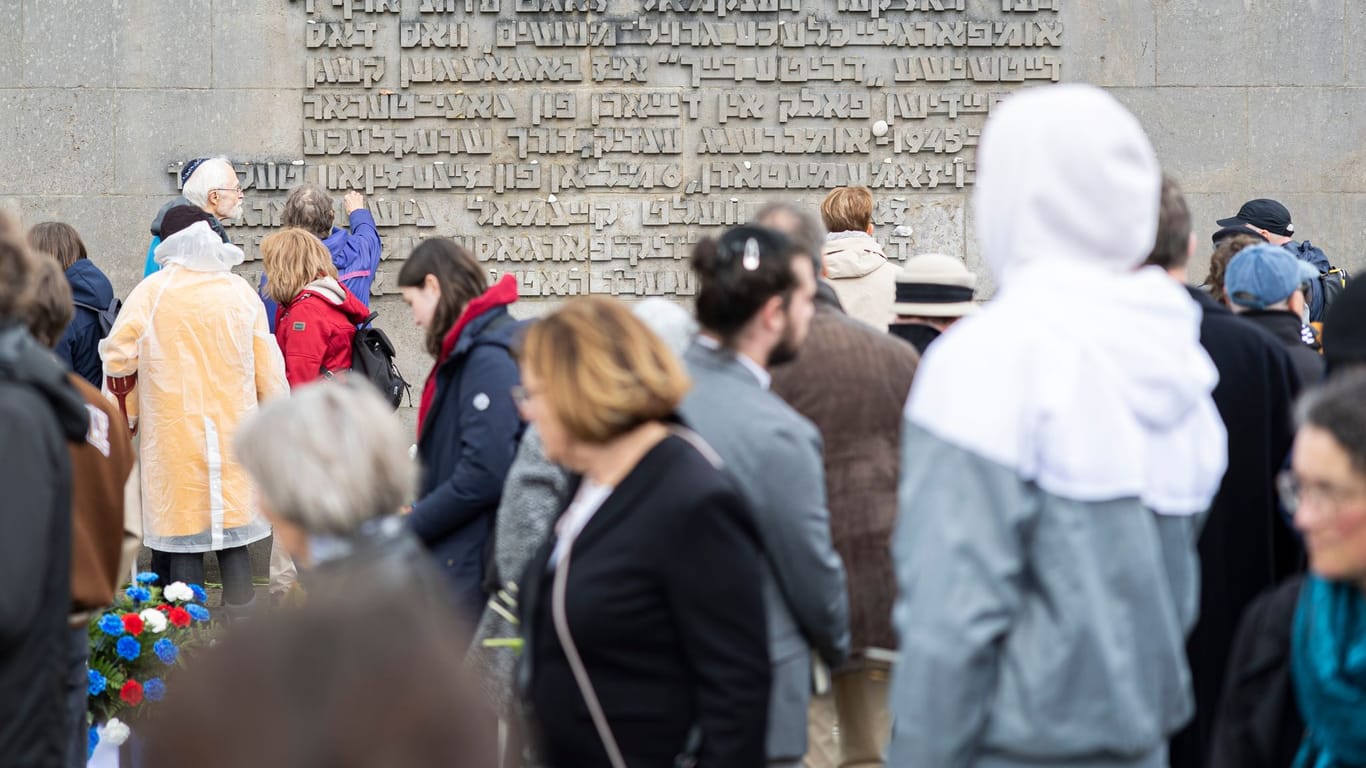 Gedenken im KZ Bergen-Belsen: Besucher vor einer Inschriftenwand auf dem Gelände.