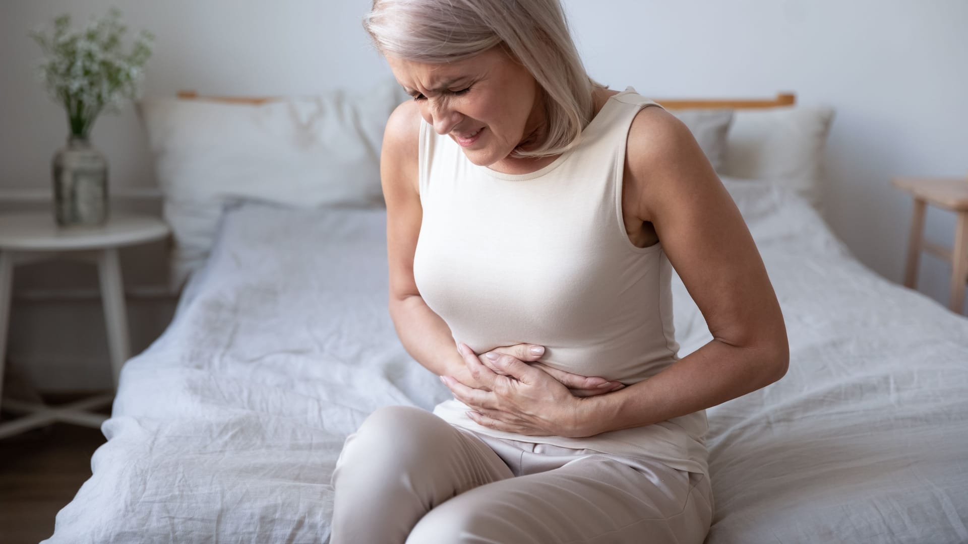 Eine Frau hält sich den Bauch.