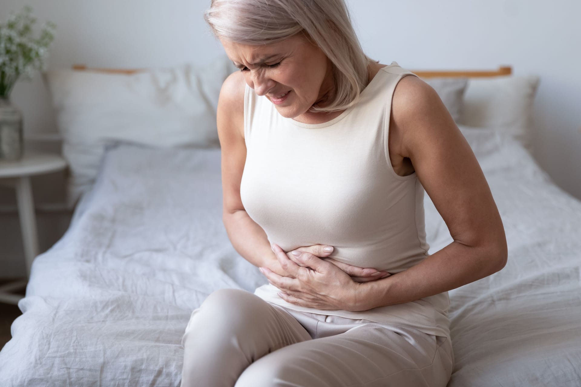 Eine Frau hält sich den Bauch.