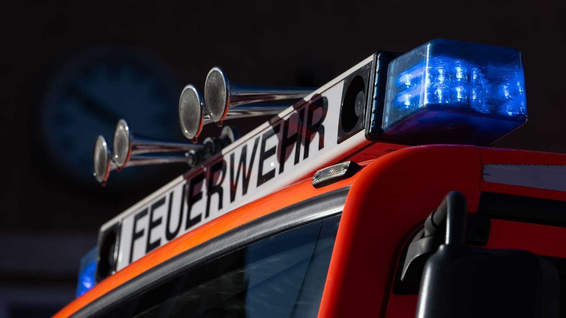 Einsatzfahrzeug der Feuerwehr mit eingeschaltetem Blaulicht Einsatzfahrzeug der Feuerwehr mit eingeschaltetem Blaulicht