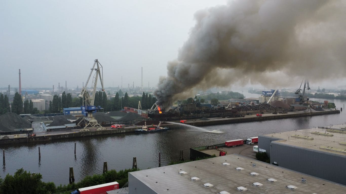 Dichter Rauch steigt über dem Hamburger Hafen auf: Die Löscharbeiten laufen mit zahlreichen Einsatzkräften.