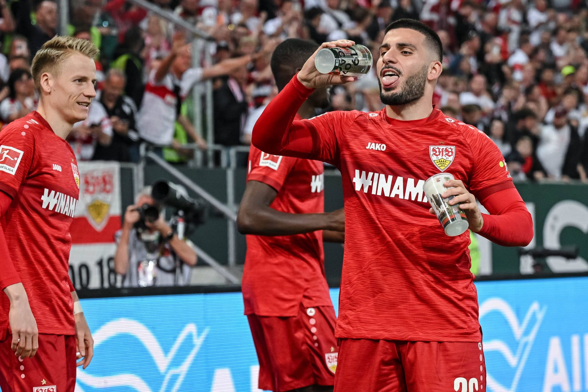 Deniz Undav (rechts) feiert mit Bierbechern: Stuttgart springt zumindest vorübergehend auf Platz zwei der Bundesliga-Tabelle.