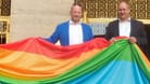 Oberbürgermeister Dirk Hilbert und CSD-Dresden-Veranstalter Ronald Zenker hissen 2021 eine Regenbogenfahne vor der Goldenen Pforte des Neuen Rathauses (Archivbild).