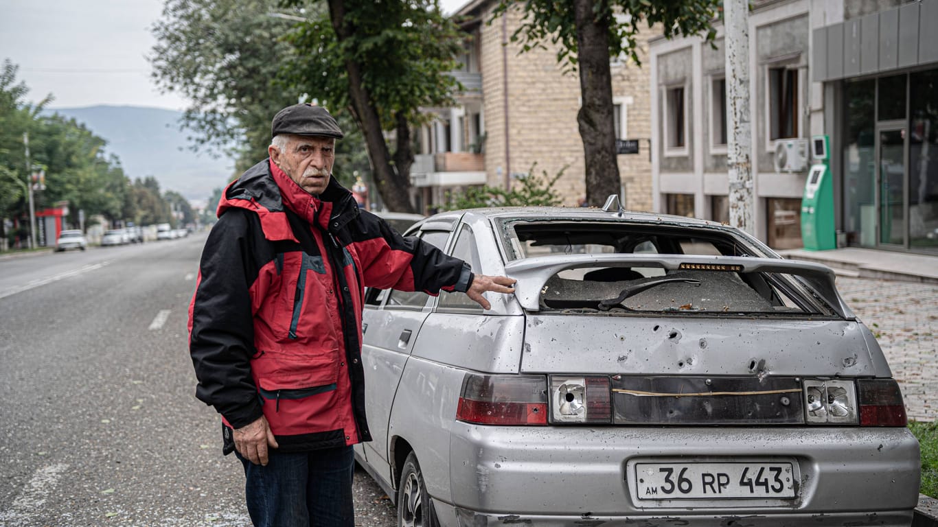 Ein Mann steht neben einem beschossenen Auto in Stepanakert, Aserbaidschan. Mit der Rückgabe von Dörfern hat Armenien einen Schritt in Richtung Frieden unternommen.