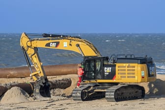Ein Hydraulikbagger an der Nordseeküste (Archivbild): Auf der Insel Baltrum wird aktuell Sand von Ost nach West bewegt, um die Badesaison vorzubereiten.