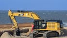 Ein Hydraulikbagger an der Nordseeküste (Archivbild): Auf der Insel Baltrum wird aktuell Sand von Ost nach West bewegt, um die Badesaison vorzubereiten.