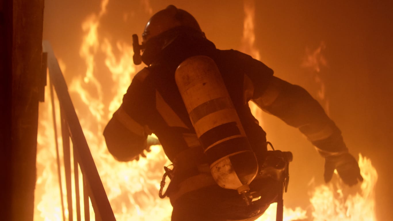 Ein Feuerwehrmann bei einem Einsatz (Symbolbild): In Steglitz ist ein Feuer in einem Mehrfamilienhaus ausgebrochen.