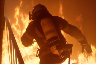 Ein Feuerwehrmann bei einem Einsatz (Symbolbild): In Steglitz ist ein Feuer in einem Mehrfamilienhaus ausgebrochen.