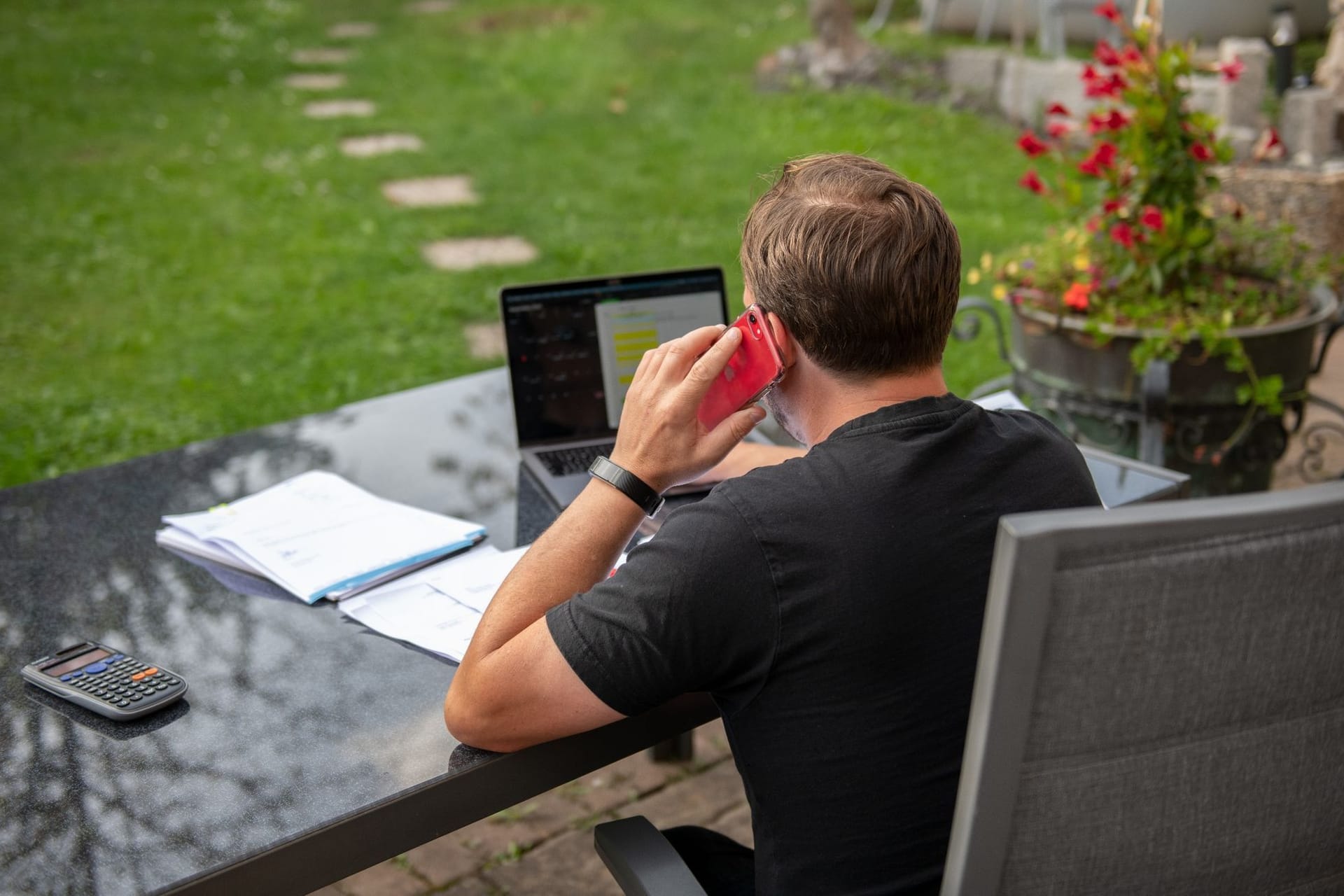 Ein Mann sitzt im Garten am Laptop Ein Mann sitzt im Garten am Laptop