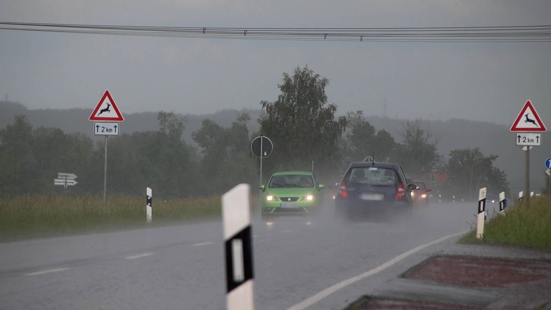 Kräftiger Schauer und Gewitter auf einer Landstraße (Symbolbild): Die Unwetter sollen bis mindestens Donnerstag anhalten.